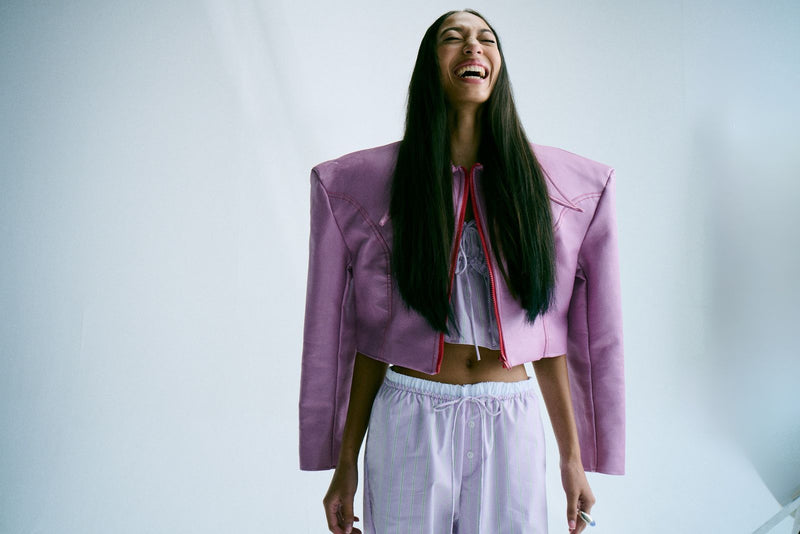 Woman with long dark Honeymoon Hair in a lilac jacket, laughing