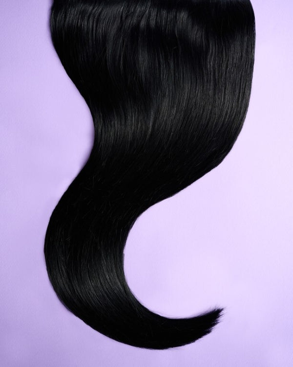 Close-up of black hair extensions with shiny, jet black strands for a bold, luxurious finish