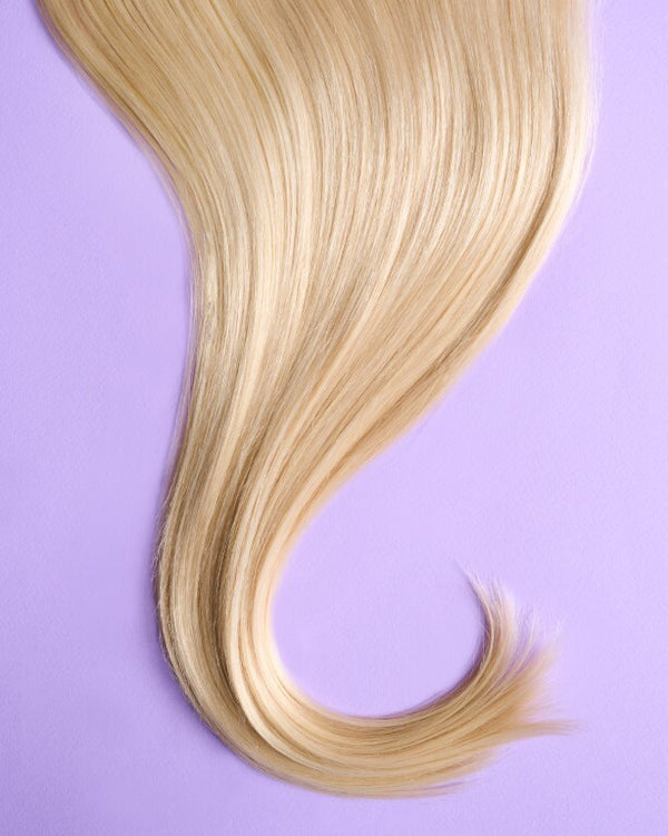 Close-up of light blonde hair extensions with bright, pale blonde hues and a natural finish