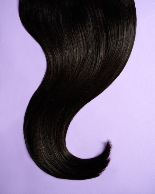 Detail view of dark brown hair extensions with deep, dark brown tones for a sleek and elegant look