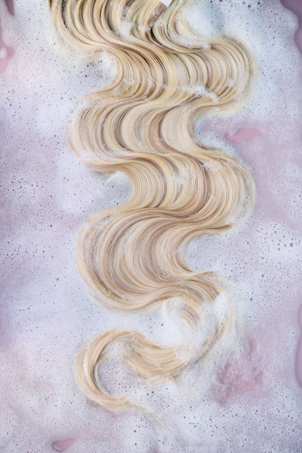 Blonde wavy weft resting in soapy water