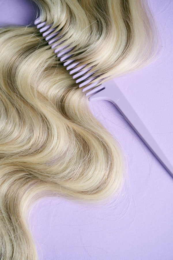 Blonde weft being combed through with the Honeymoon comb